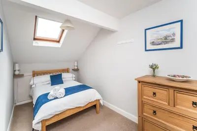 a bedroom with a bed and a wooden dresser at Alban Rise in Keswick