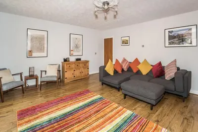 a living room with a couch and chairs and a rug at Alban Rise in Keswick