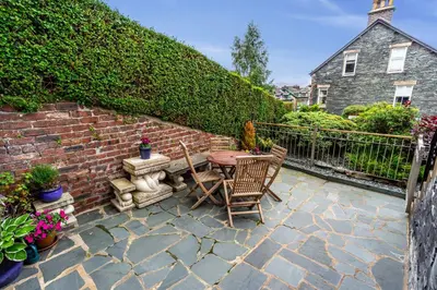 a patio with a table and chairs and a brick wall at The Ridgeway in Keswick