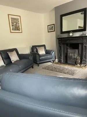 a living room with a couch and a fireplace at Tawny Cottage in Portinscale