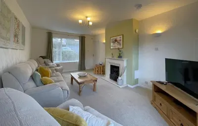 a living room with a couch and a tv at Roslin in Portinscale