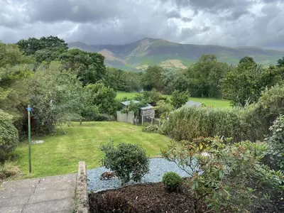 a view of a garden with mountains in the background at Roslin in Portinscale
