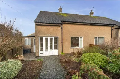 a brick house with a white door at Roslin in Portinscale