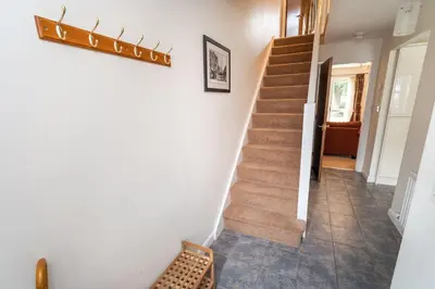 a staircase in a home with white walls at Quaver Cottage in Keswick