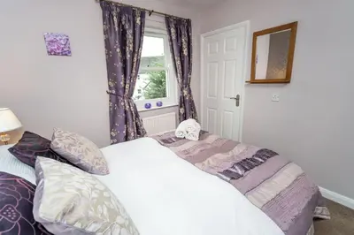 a bedroom with a bed and a window at Elm Cottage in Keswick