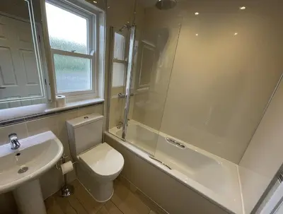 a bathroom with a toilet and a shower and a sink at Elm Cottage in Keswick