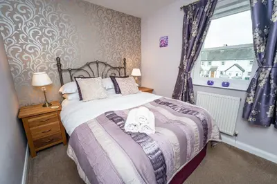 a bedroom with a bed and a window at Elm Cottage in Keswick