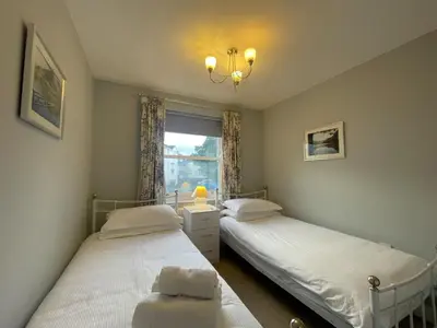 two twin beds in a room with a window at Coledale in Keswick