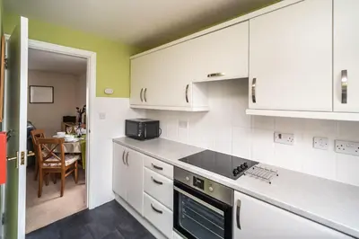 a kitchen with white cabinets and a stove top oven at Coledale in Keswick