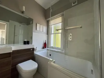 a bathroom with a toilet and a tub and a sink at Bridge Cottage in Keswick