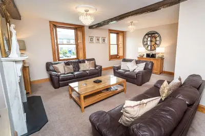 a living room with leather couches and a coffee table at Bridge House in Keswick