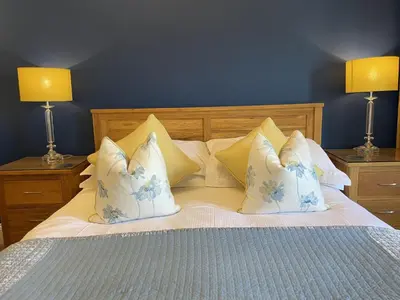 a bedroom with a bed with blue walls and two lamps at Bridge House in Keswick