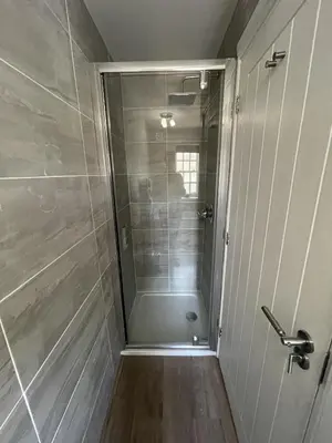 a shower with a glass door in a bathroom at Bridge House in Keswick