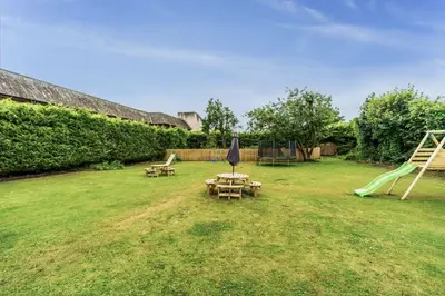 a yard with a playground with a table and swings at Bridge House Apartment 1 in Keswick
