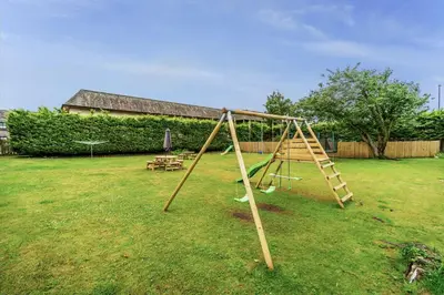 a wooden swing set in a yard at Bridge House Apartment 3 in Keswick