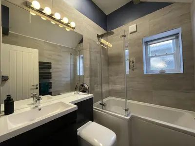 a bathroom with a sink and a toilet and a tub at Bridge House Apartment 3 in Keswick