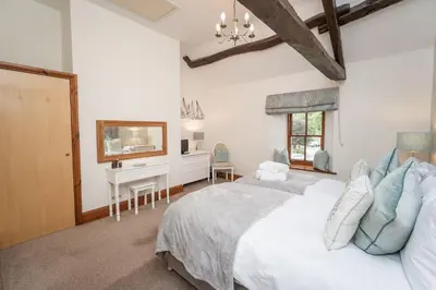 a bedroom with a large white bed and a desk at Bridge House Apartment 3 in Keswick