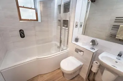 a white bathroom with a toilet and a sink at Bridge House Apartment 2 in Keswick