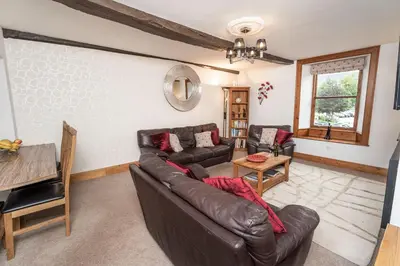 a living room with a leather couch and a table at Bridge House Apartment 2 in Keswick