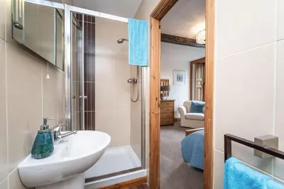 a bathroom with a white sink and a shower at Bridge House Apartment 2 in Keswick