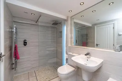 a bathroom with a sink and a toilet and a mirror at Bridge Mews in Keswick