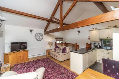 a kitchen and living room with wooden beams at Bridge Mews in Keswick