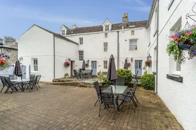 a patio with tables and chairs in front of a building at Bridge Mews in Keswick