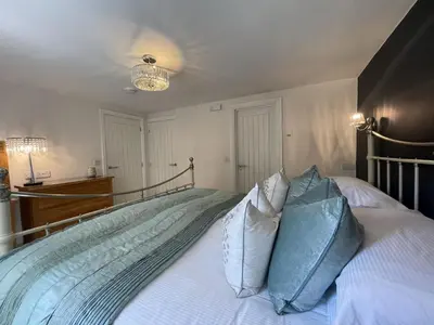 a bedroom with a large bed with blue pillows at Bridge Mews in Keswick