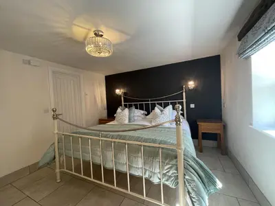 a bed in a bedroom with a black wall at Bridge Mews in Keswick