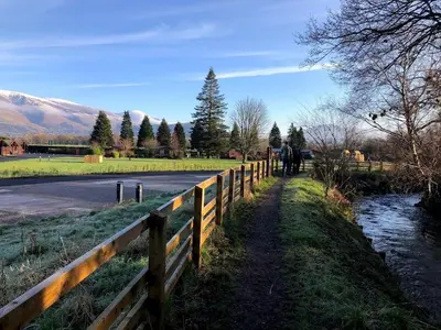 a fence next to a road next to a river at Causey View in Braithwaite