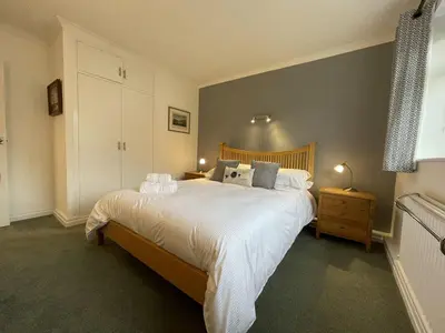 a bedroom with a large bed with white sheets and pillows at Causey View in Braithwaite