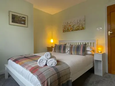 a bedroom with a bed with towels on it at Byways in Keswick