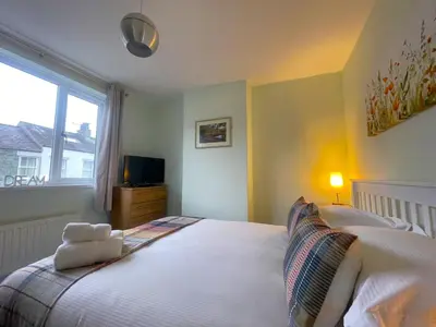 a bedroom with a large white bed with a window at Byways in Keswick