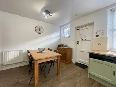 a kitchen with a table and a clock on the wall at Birchgate in Keswick