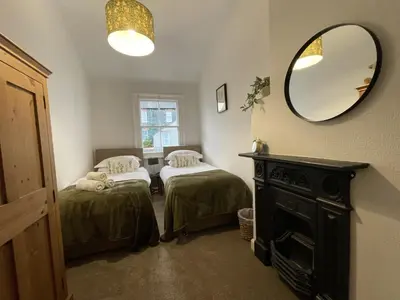 a room with two beds and a mirror at Birchgate in Keswick