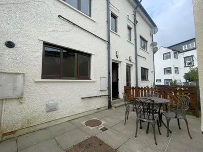 a patio with a table and chairs next to a building at Alison's View in Keswick