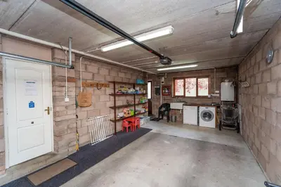 a garage with a white door in a brick wall at Alison's View in Keswick
