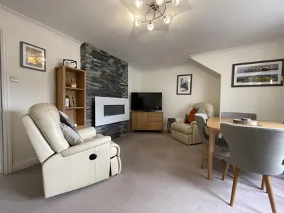 a living room with a table and chairs and a tv at Maiden Moor in Keswick