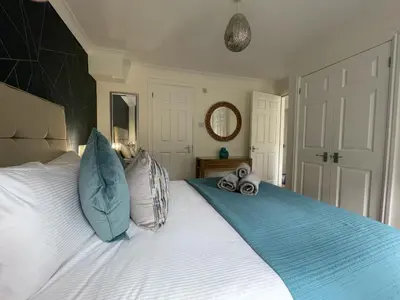 a bedroom with a large bed with blue pillows at Maiden Moor in Keswick