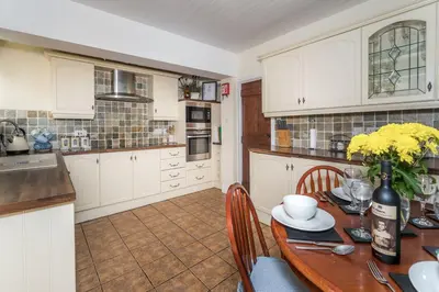 a kitchen with a wooden table with yellow flowers on it at Millside Cottage in Braithwaite