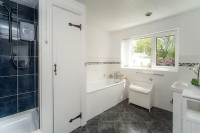 a bathroom with a tub and a toilet and a sink at Millside Cottage in Braithwaite