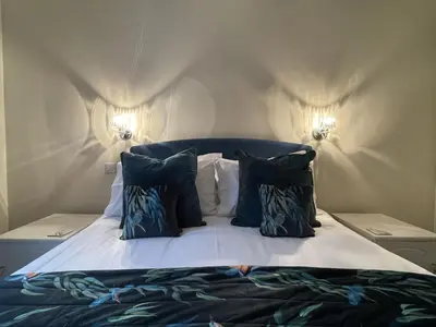 a bedroom with a bed with blue and white pillows at Lake View Cottage in Braithwaite