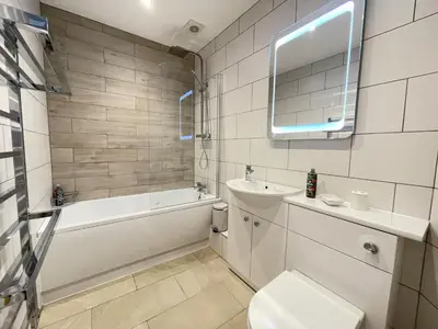 a bathroom with a sink and a tub and a toilet at Lake View Cottage in Braithwaite