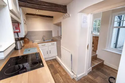 a kitchen with a sink and a stove top oven at Jasmine Cottage in Portinscale
