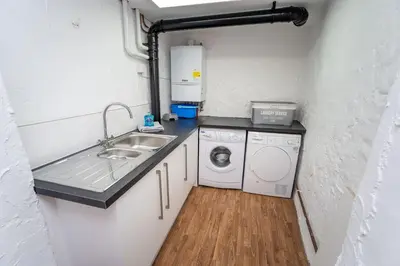 a small kitchen with a sink and a washing machine at Daisy Cottage in Keswick