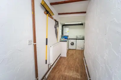 a hallway in a small room with a broom at Daisy Cottage in Keswick