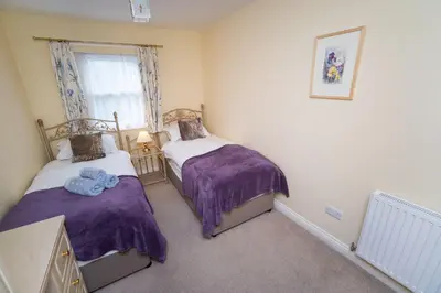 a bedroom with two beds and a window at Greta Bank in Keswick
