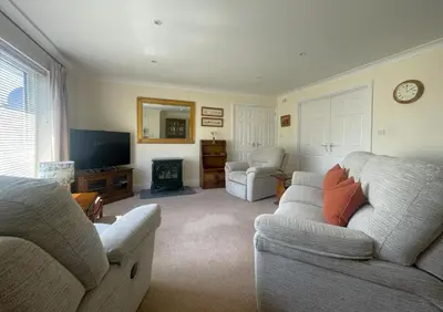 a living room with two couches and a television at Crosthwaite Gardens in Keswick