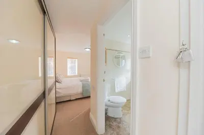 a bathroom with a toilet and a bedroom with a bed at Crosthwaite Gardens in Keswick