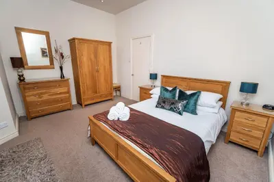 a bedroom with a large bed and wooden furniture at Crandy Nook in Keswick